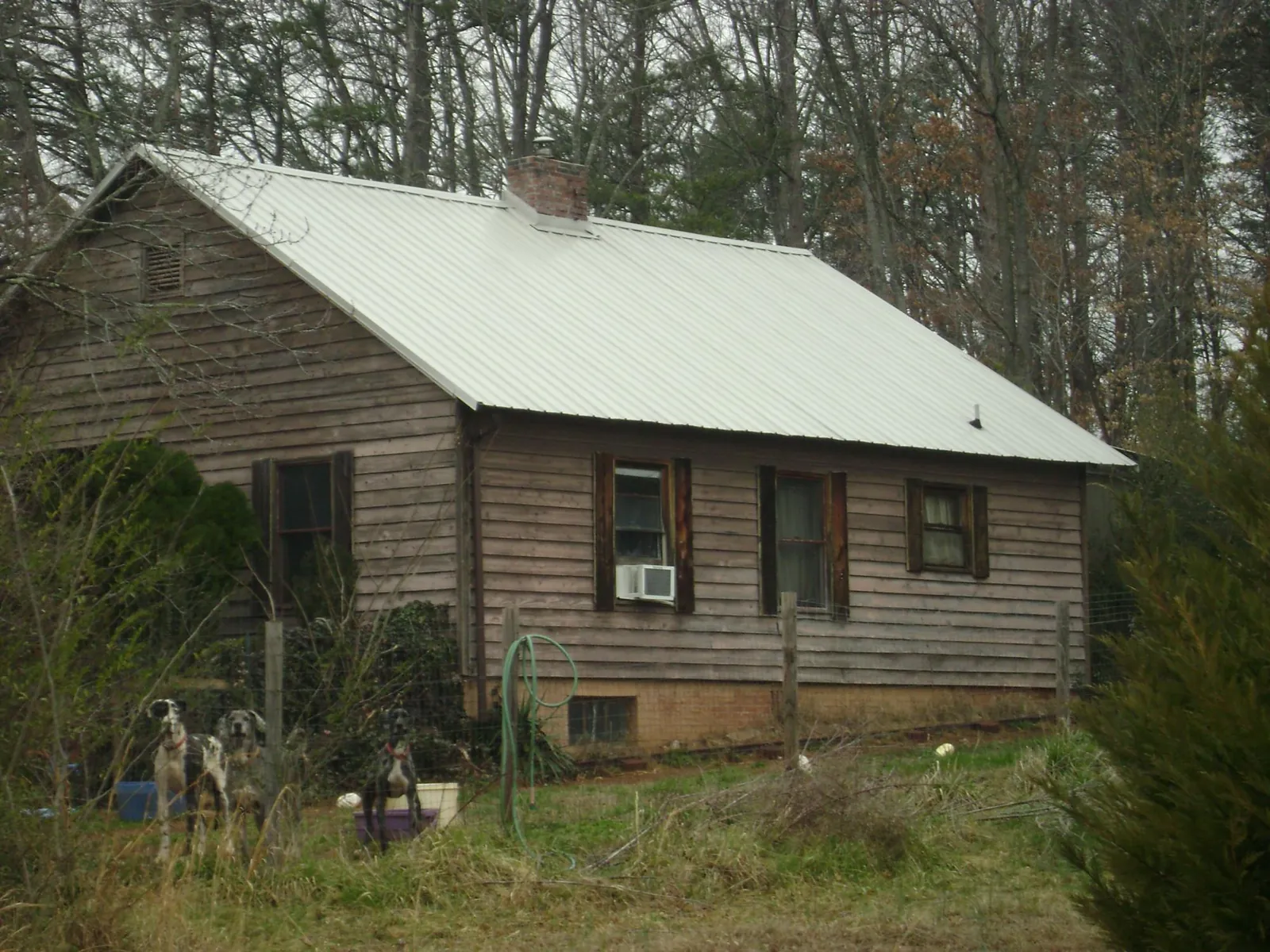 White metal roof on an old wood sided farmhouse, from a Metal Roof Installation job in Ossian